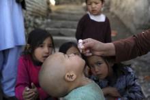 Shabana Maani, gives a polio vaccination to a child in the old part of Kabul, Afghanistan, Monday March 29, 2021 (AP Photo/Rahmat Gul)